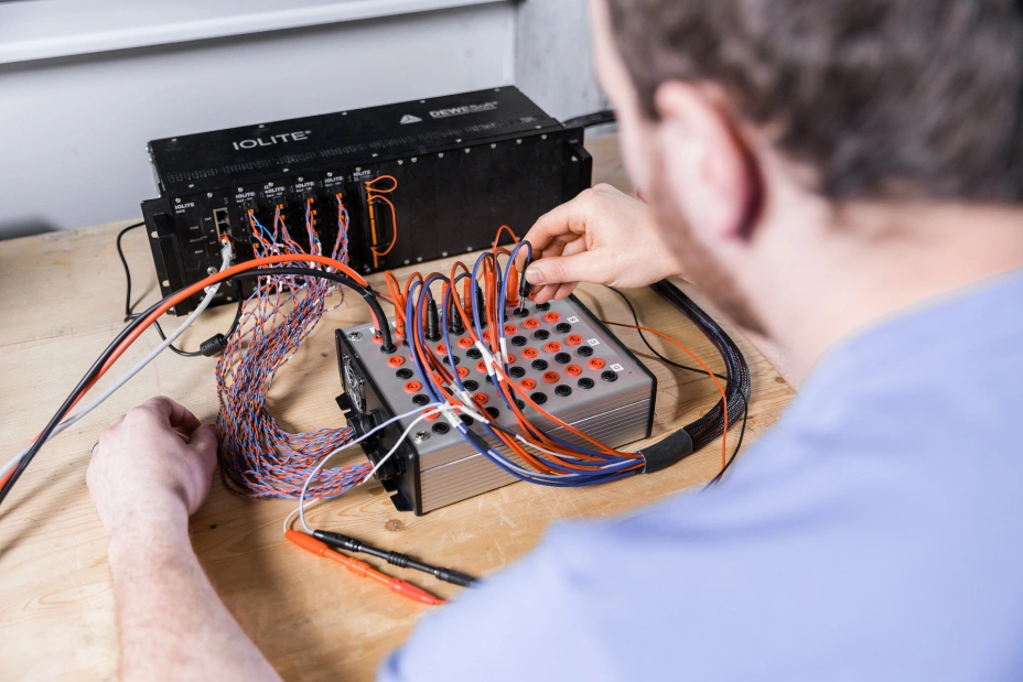 technik specjalistyczny podłącza kable do badań prądu słaboprądowego